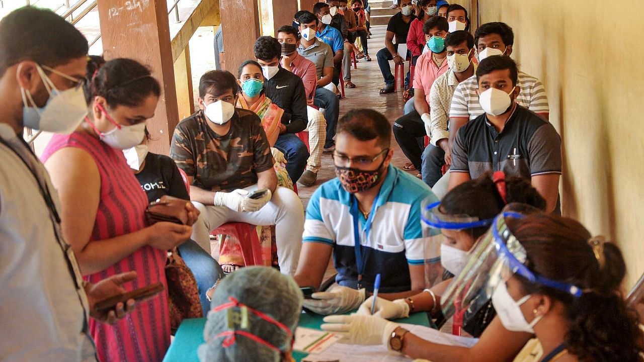 Beneficiaries wait in a queue to receive Covid-19 vaccine at a Covid-19 vaccination centre in Chikmagalur. Credit: PTI Photo