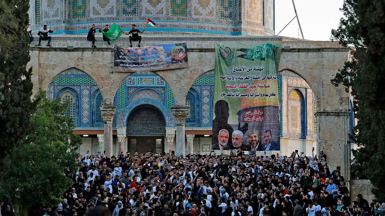Palestinian worshippers raise the Hamas and the Palestinian flag along with a Hamas poster with portraits of its leaders, at the Dome of the Rock shrine in the al-Aqsa mosques compound in Jerusalem's Old City. Credit: AFP Photo