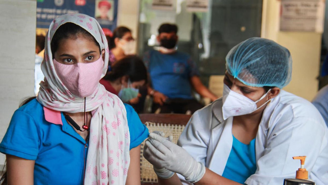 A health worker administers a dose of Covid-19 vaccine as part of the third phase of the inoculation drive, at Government Polyclinic Covid Vaccination Centre, in Gurugram. Credit: PTI Photo
