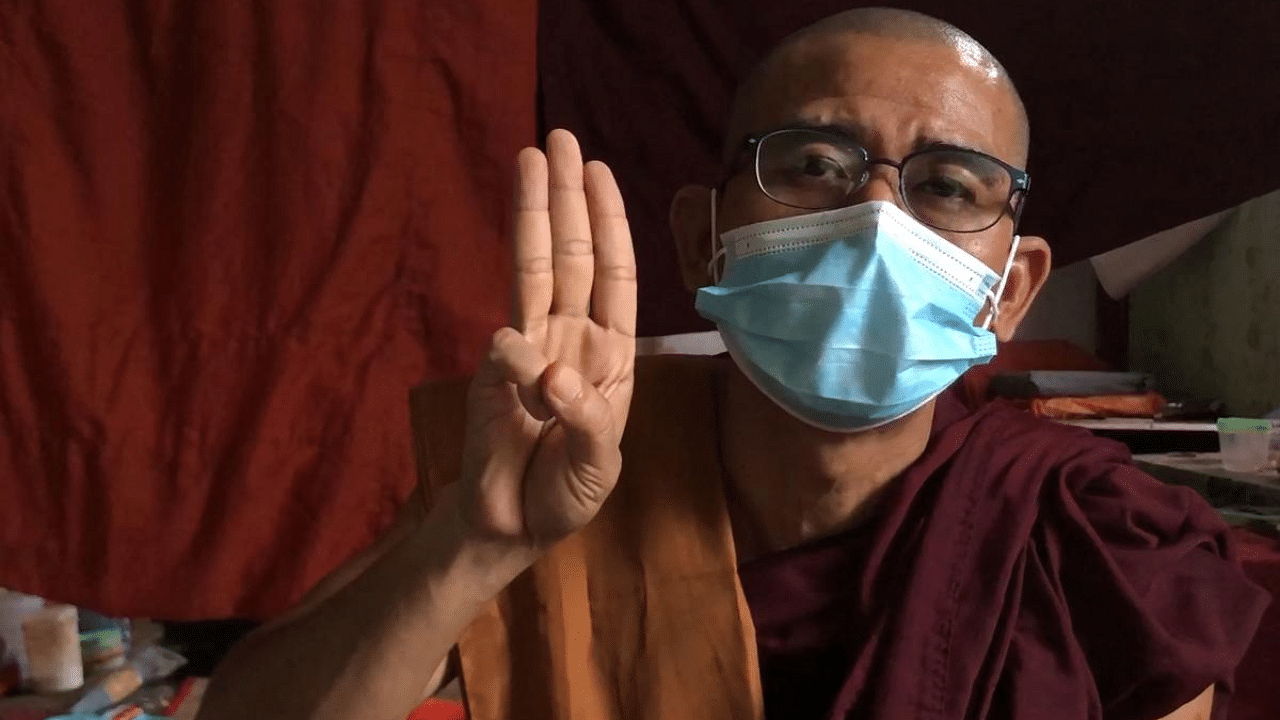 This screengrab from AFPTV video footage taken on April 25, 2021 shows Buddhist monk Shwe Ohh Sayardaw, who has taken part in demonstrations with protesters against the military coup, making the three-finger salute. Credit: AFP