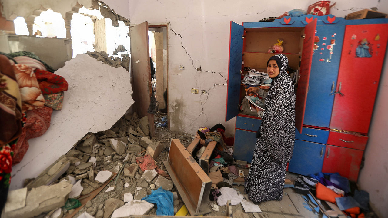 A Palestinian woman reacts as she collects her belongings inside her heavily damaged house in the aftermath of Israeli air and artillery strikes as cross-border violence between the Israeli military and Palestinian militants continues, in the northern Gaza Strip. Credit: Reuters Photo