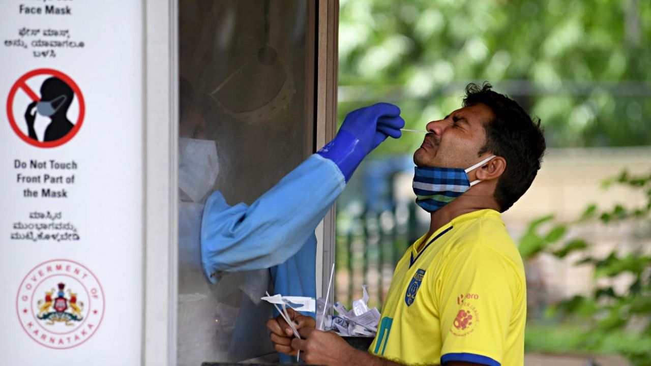 Healthcare worker tests a person for coronavirus. Credit: DH Photo