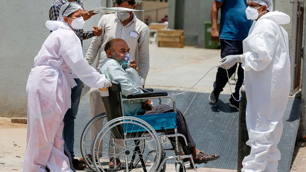Health workers move a stable Covid-19 patient to another hospital to make space for critical patients, as coronavirus cases surge in Ahmedabad. Credit: PTI Photo