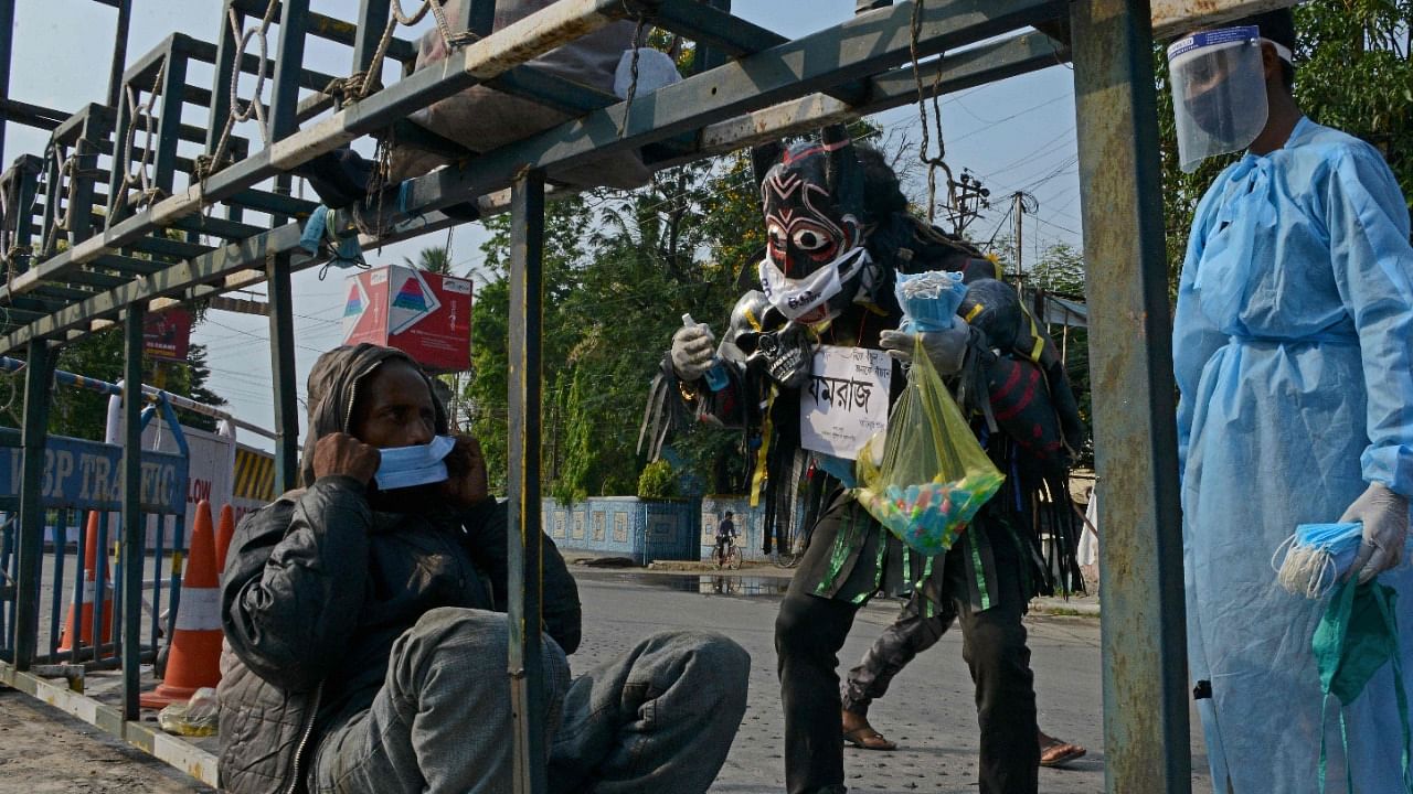 A volunteer dressed as Yamraj the Hindu lord of death and justice, roams around the streets creating awareness to follow the Covid-19 coronavirus safety protocols while also distributing face-masks and hand sanitisers to people in Siliguri on May 14, 2021. Credit: AFP Photo