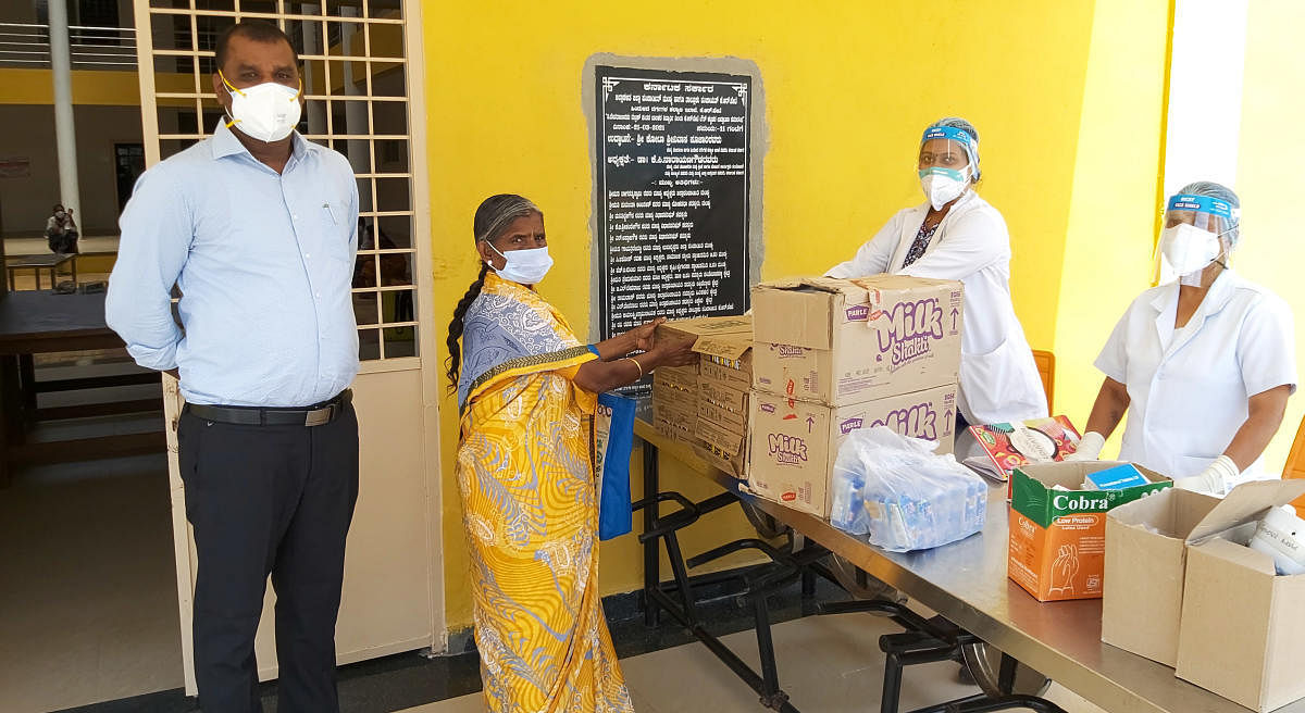 Sharadamma of Hiralahalli, KR Pet taluk seen with Tahsildar M Shivamurthy and healthcare professionals, at the Covid Care Centre in Hosaholalu, KR Pet town, recently. DH Photo