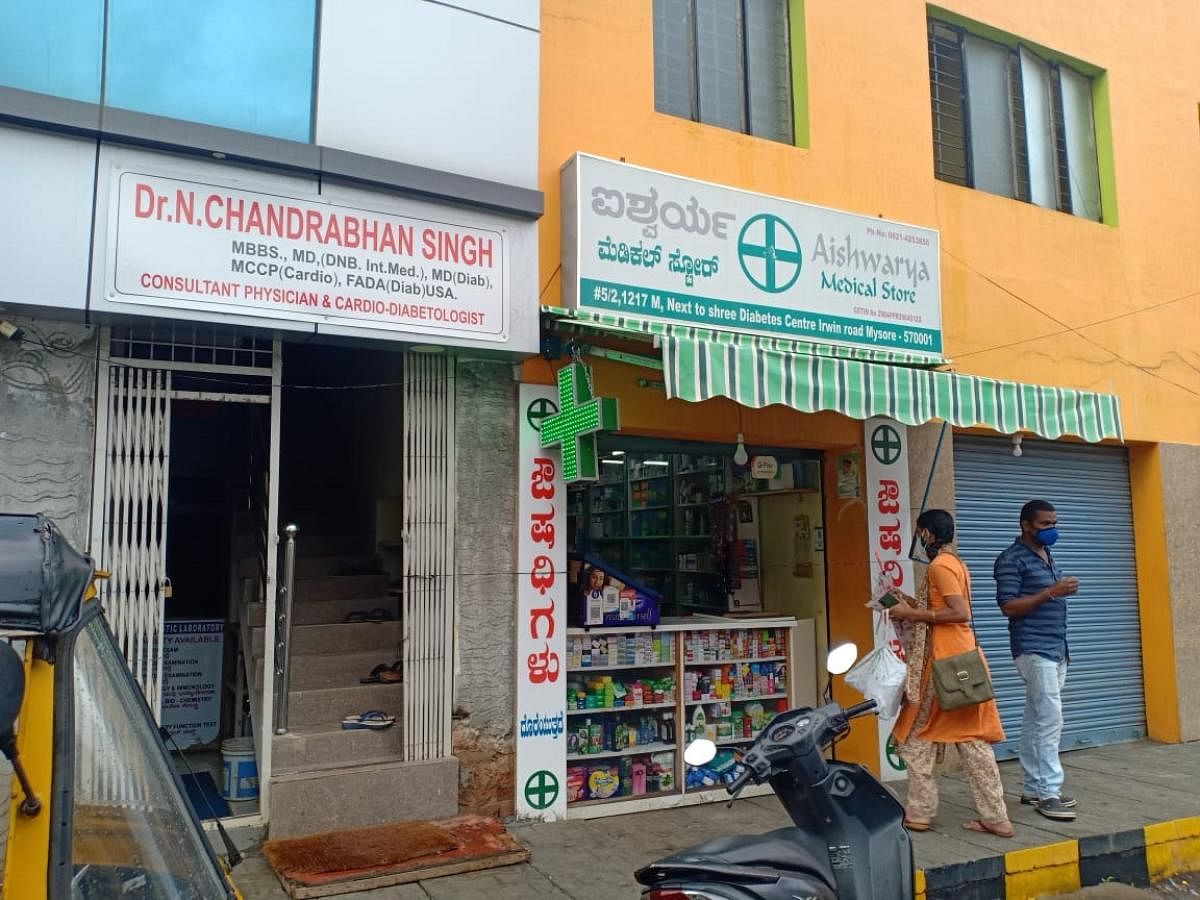 A woman approaches a medical store on Irwin Road near Krishnaraja Hospital to buy medicines. DH Photo