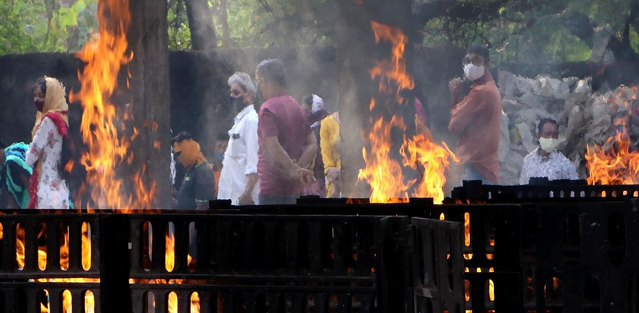 Family member during the cremation of COVID-19 victim, at a Cremation Ground Mokshadham Ghat in Nagpur, Maharashtra on Saturday. May 15, 2021. Credit: PTI Photo