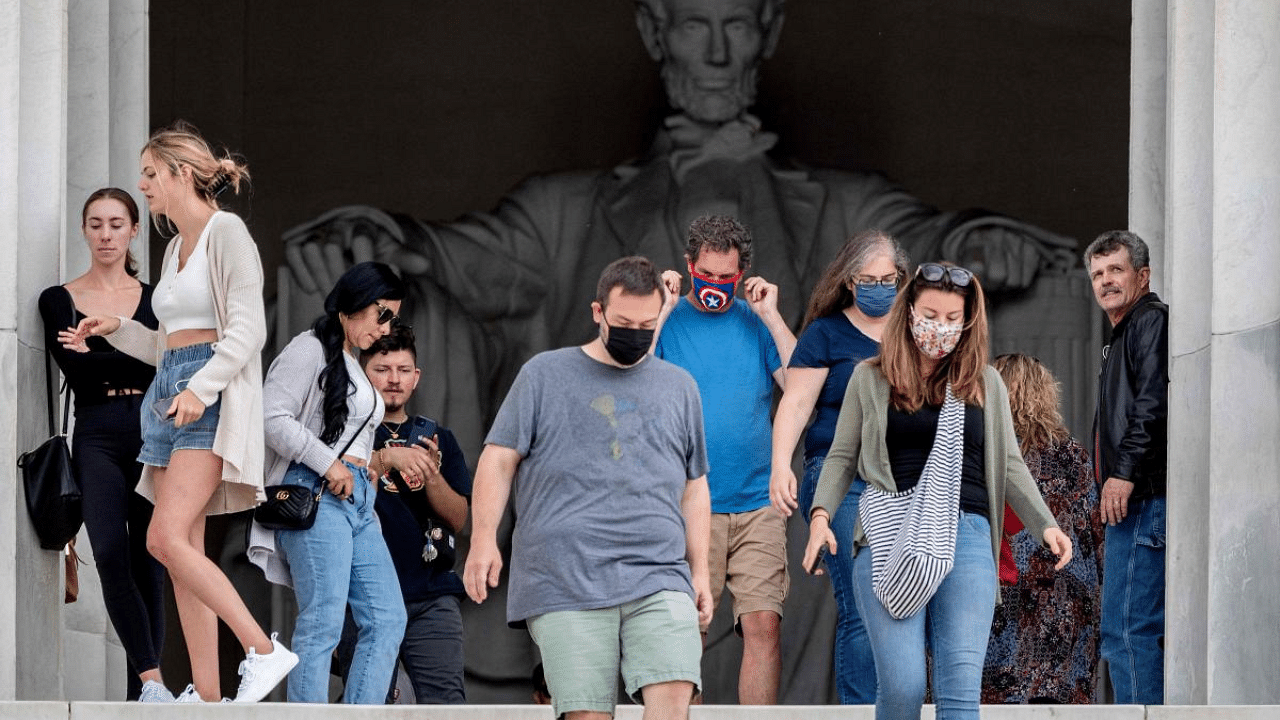 Tourists, some in face masks while others are not, visit the Lincoln Memorial in Washington. Credit: AFP Photo