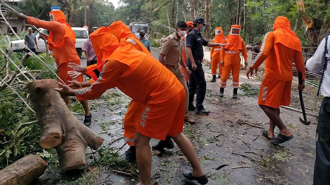 This handout photo released on May 16, 2021 by the National Disaster Response Force (NDRF) shows National Disaster Response Force (NDRF) personnel clearing fallen trees from a road following severe cyclonic storm 'Tauktae' at Margao in Goa. Credit: AFP Photo/NDRF