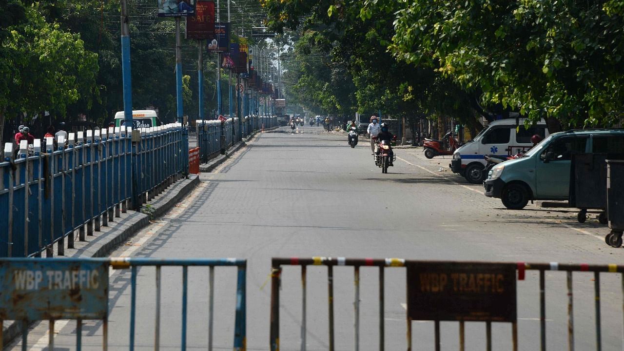 A semi-deserted road is seen during a 15-day partial lockdown imposed to curb the spread of the Covid-19 coronavirus, in Siliguri. Credit: AFP Photo