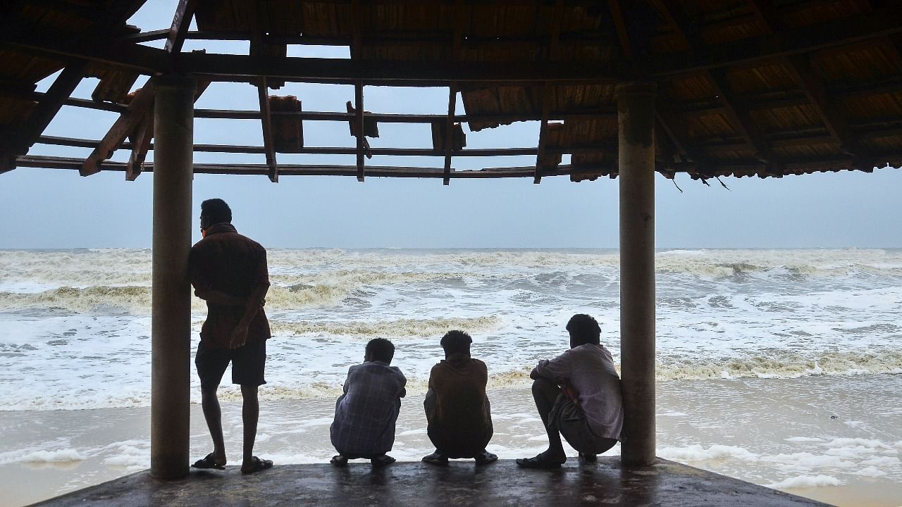 Local fishermen watch the effects of cyclone Tauktae, at Panamburu beach area near Mangaluru. Credit: PTI Photo