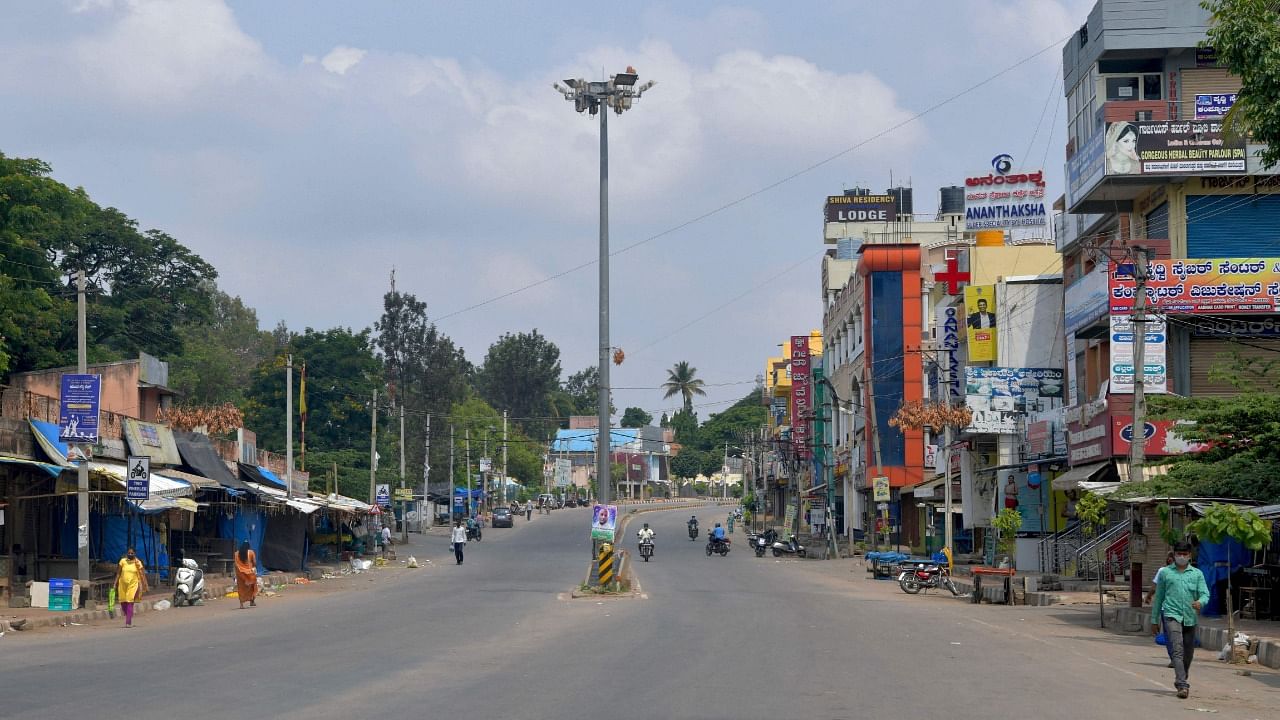 People are seen on a partially deserted road after a lockdown was imposed by the state government as a preventive measure against the spread of the Covid-19 coronavirus in Bengaluru on May 10, 2021. Credit: AFP Photo