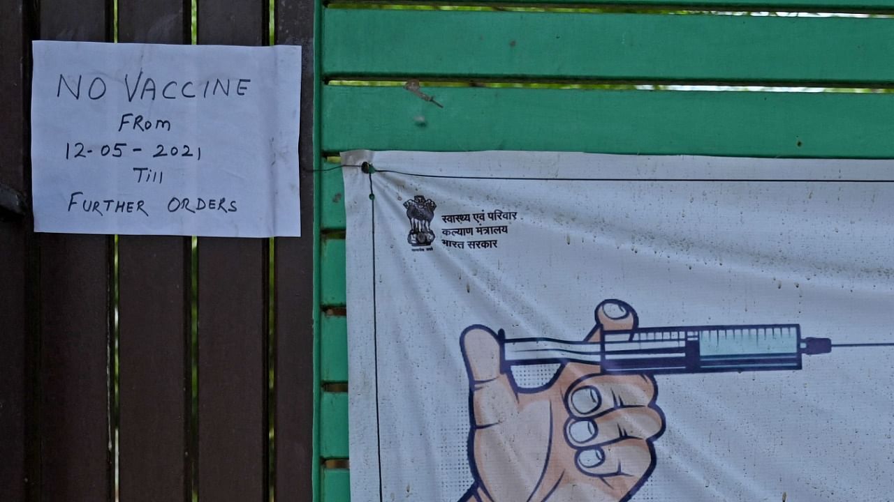 A notice placed on the gate of a Covid-19 coronavirus vaccination center mentions non availability of the Covaxin vaccine until further orders in New Delhi on May 13, 2021. Credit: AFP Photo