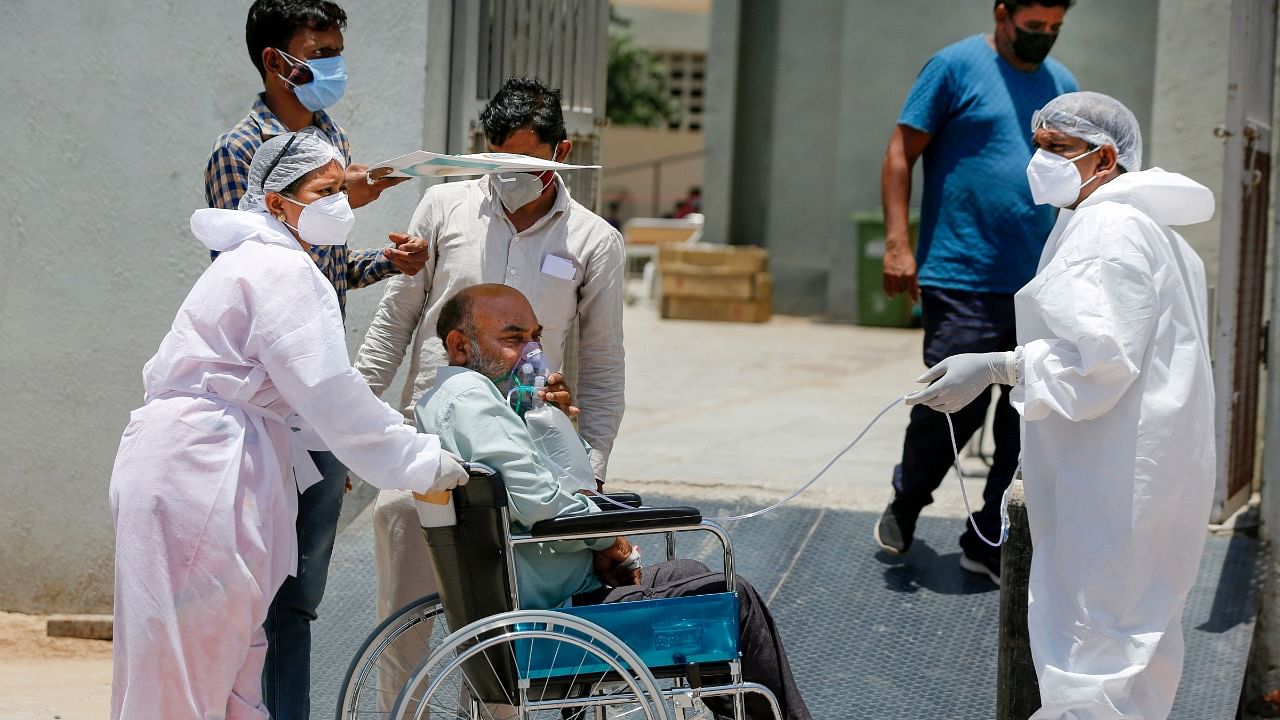 Health workers move a stable Covid-19 patient to another hospital to make space for critical patients, as coronavirus cases surge in Ahmedabad, Wednesday, May 12, 2021. Credit: PTI Photo