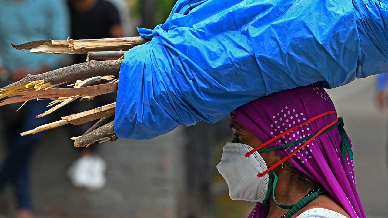 Workers can be seen wearing face masks as per Covid-19 coronavirus safety protocols in New Delhi on May 18, 2021. Credit: AFP Photo