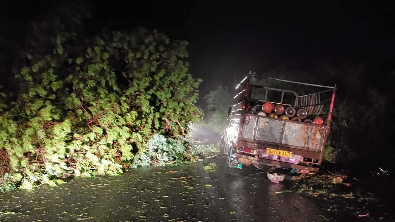 A truck loaded with oxygen cylinders stuck as trees fell due to impact of approaching Cyclone Tauktae, near Mahua, some 300 kms from Ahmedabad. Credit: AFP Photo