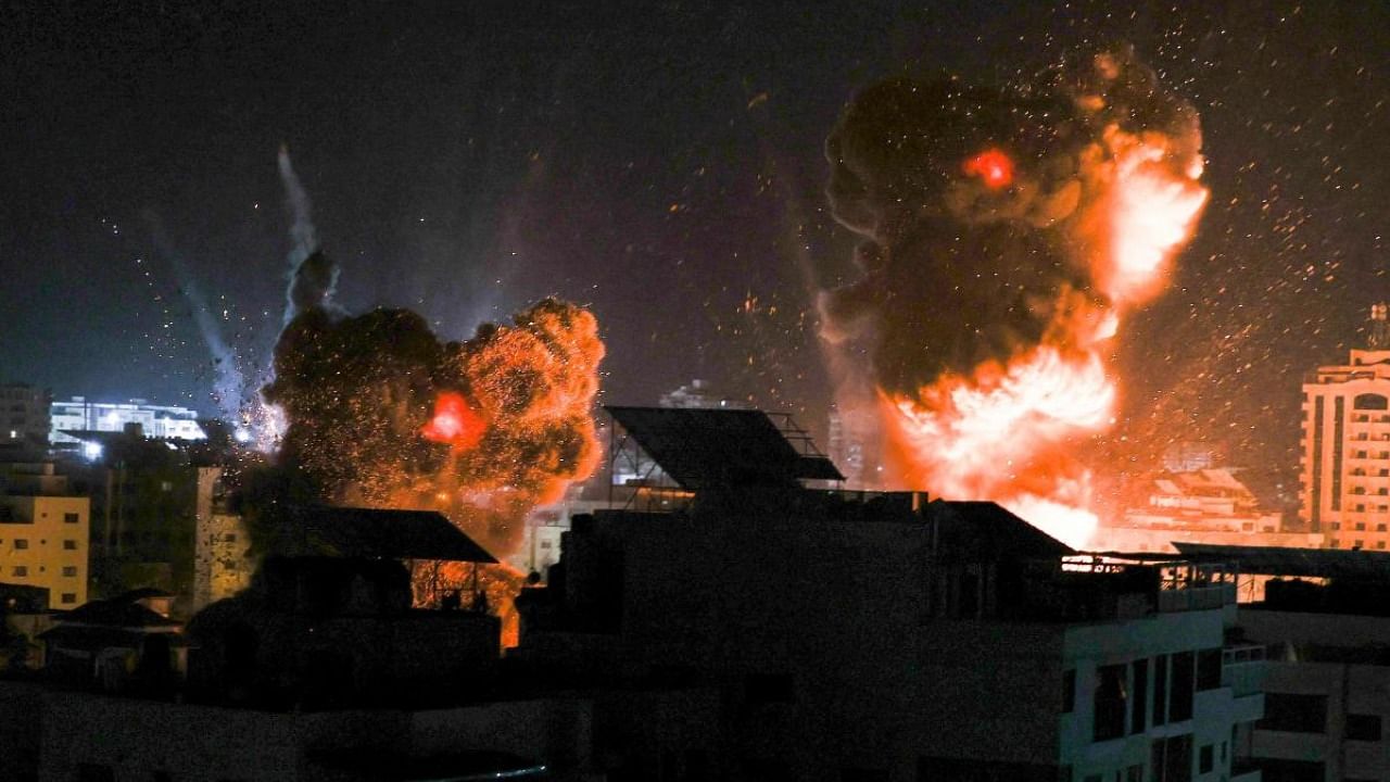 Explosions lite-up the night sky above buildings in Gaza City as Israeli forces shell the Palestinian enclave. Credit: AFP Photo