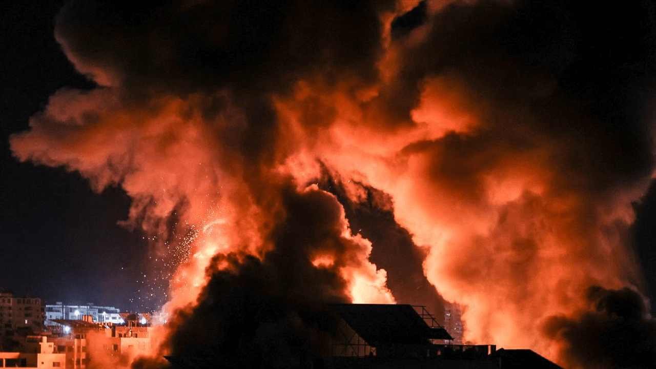 Explosions lite-up the night sky above buildings in Gaza City as Israeli forces shell the Palestinian enclave. Credit: AFP Photo