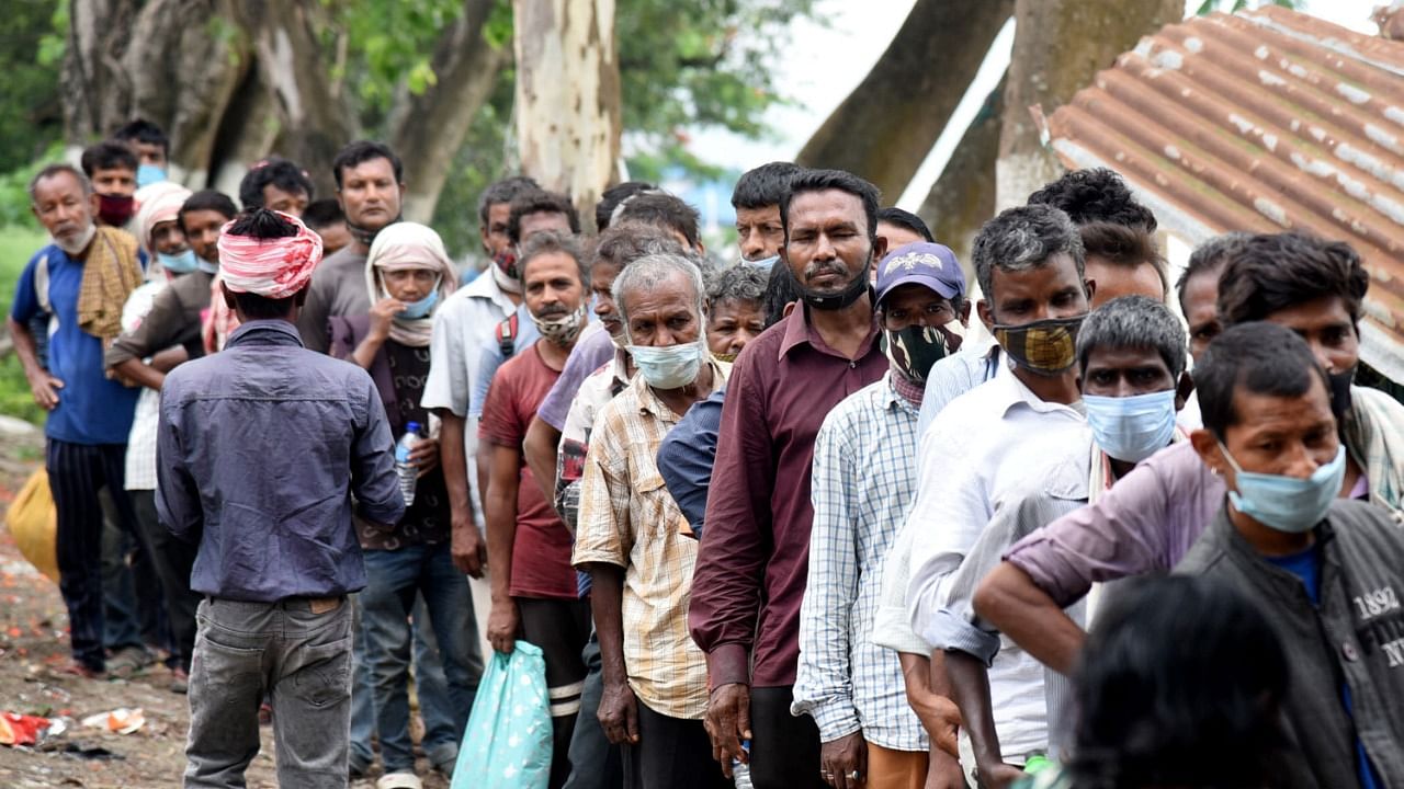 Needy people queue up for free food being distributes by volunters during the Covid-19 lockdown, in Guwahati, Tuesday, May 18, 2021. Credit: PTI Photo