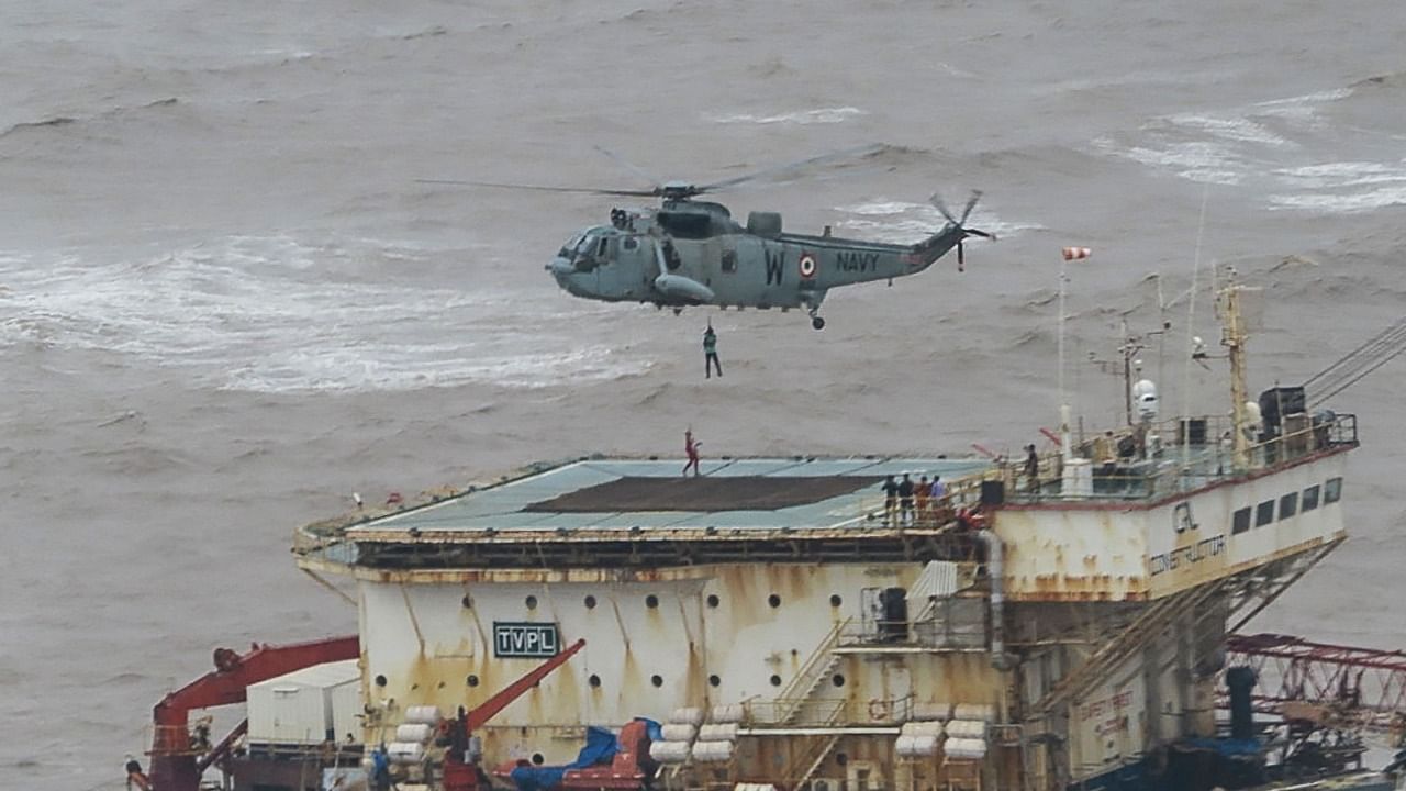 This handout photograph taken on May 18, 2021 and released by the Indian Navy shows stranded workers from a barge, which had gone adrift amidst heavy rain and strong winds due to Cyclone Tauktae, being airlifted by naval personnel on an Indian Navy Seaking helicopterduring an evacuation operation, in the Arabian sea. Credit: AFP Photo