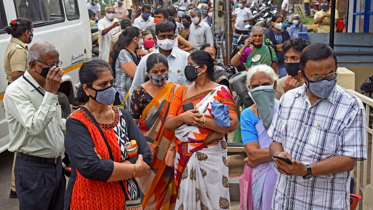 Citizens wait for Covid-19 vaccine outside a vaccination centre in Karnataka. Credit: DH Photo/ S Manjunath