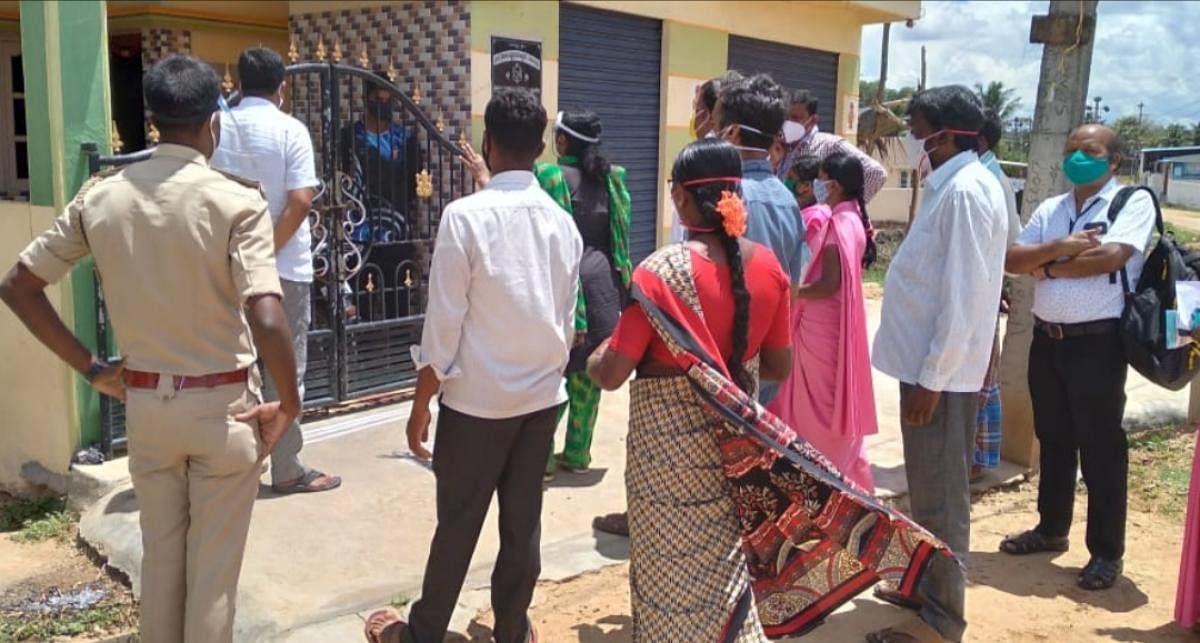 Health workers visit houses of Covid infected patients at Gopalapura village in Mysuru. DH FILE PHOTO