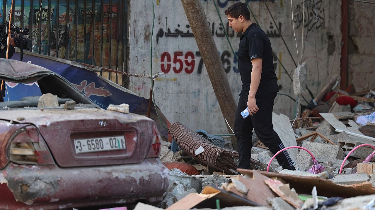 A Palestinian man walks amidst debris in the aftermath of an Israeli air strike in Gaza City. Credit: AFP Photo