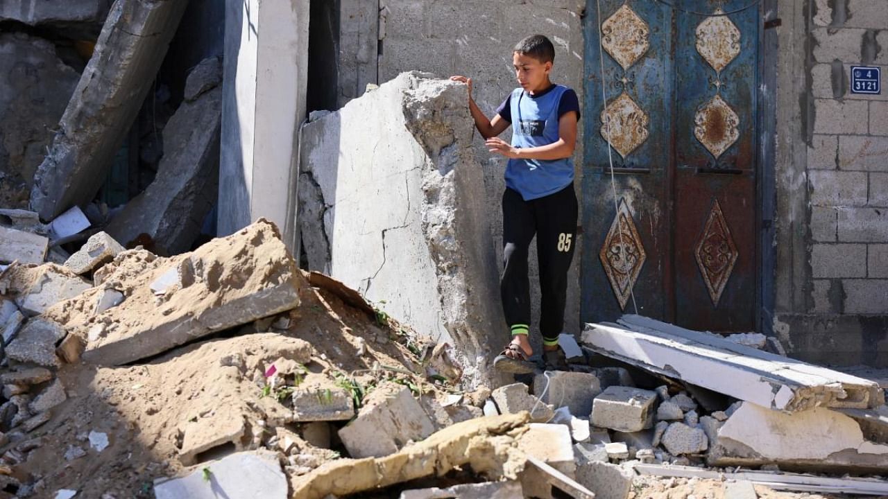 A Palestinian boy checks the aftermath of Israeli airstrikes in Rafah in the southern Gaza Strip on May 19, 2021. Credit: AFP Photo