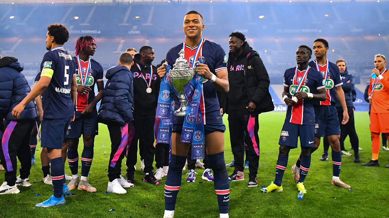 Paris Saint-Germain's French forward Kylian Mbappe celebrates with the trophy after winning the French Cup final football match between Paris Saint-Germain and Monaco at the Stade de France. Credit: AFP Photo