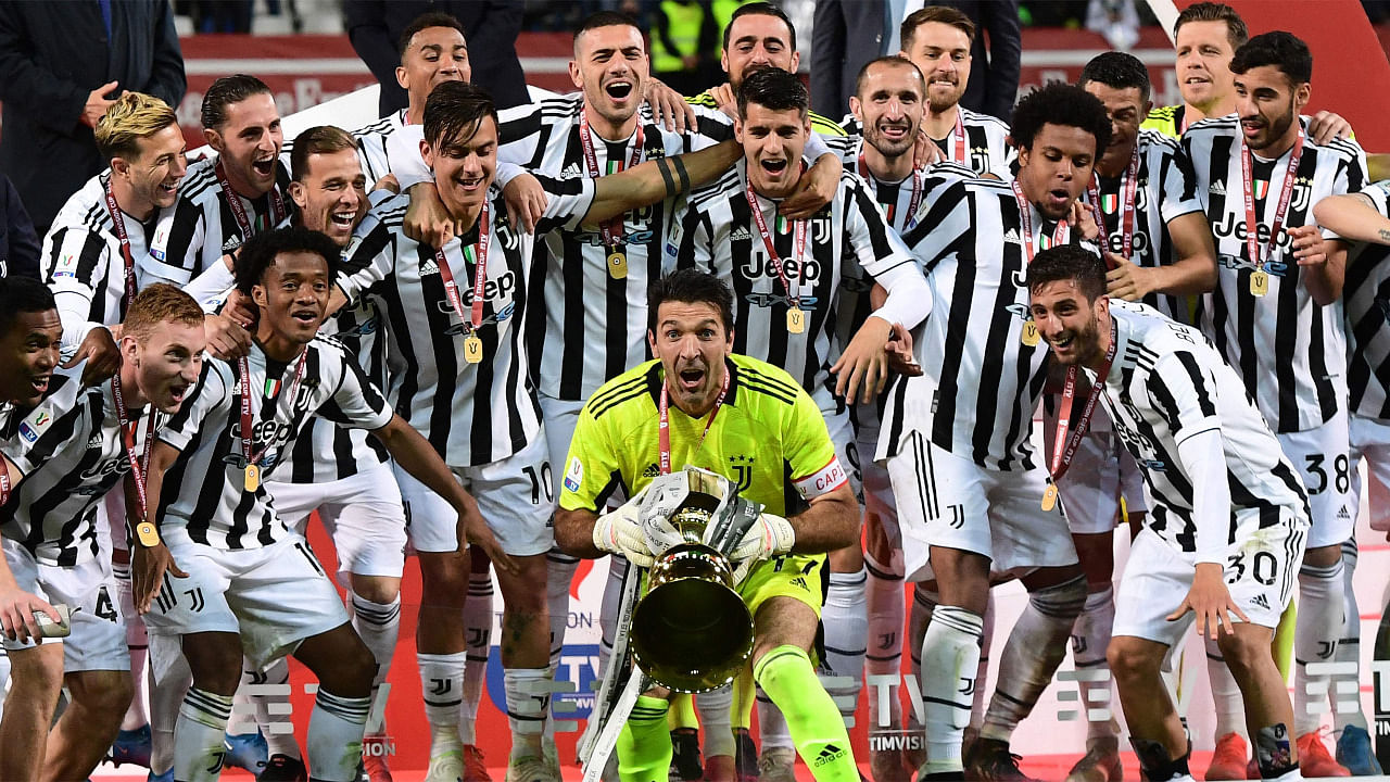 Juventus' Italian goalkeeper Gianluigi Buffon holds the winner's trophy as Juventus players celebrate winning the final of the Italian Cup. Credit: AFP Photo