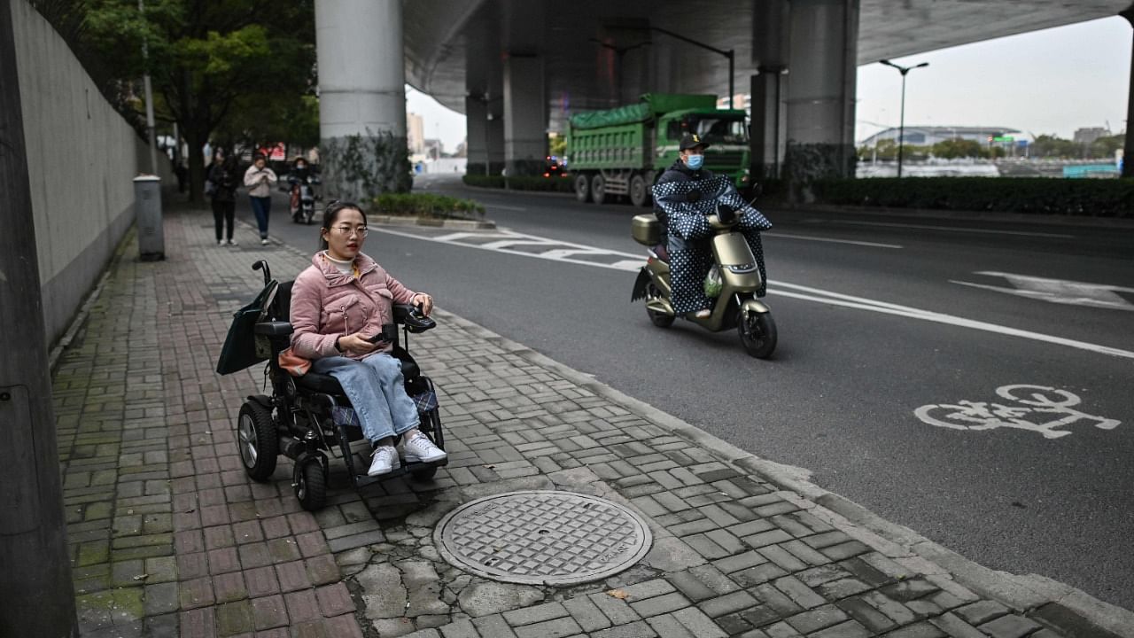 Video blogger Zhao Hongcheng goes along a street on her way to work in Shanghai. Credit: AFP Photo