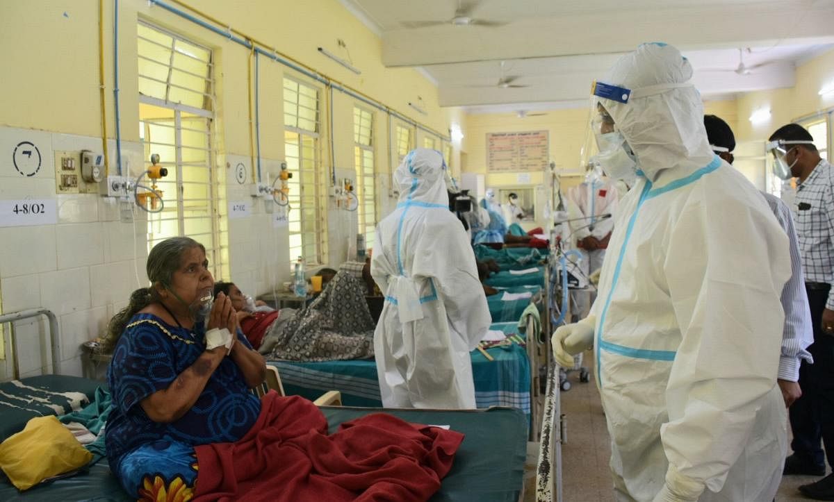 Deputy Chief Minister C N Ashwath Narayan in PPE kit interacts with Covid patients, at the district covid hospital in Mandya on Thursday. DH PHOTO