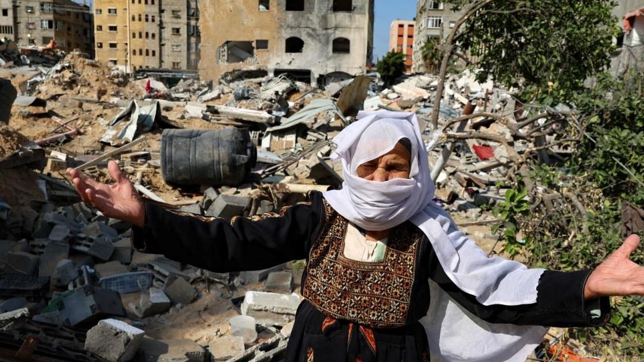 An elderly Palestinian woman reacts in front of her home, damaged by Israeli bombardment, in Beit Lahia in the northern Gaza Strip, on May 20, 2021. Credit: AFP Photo