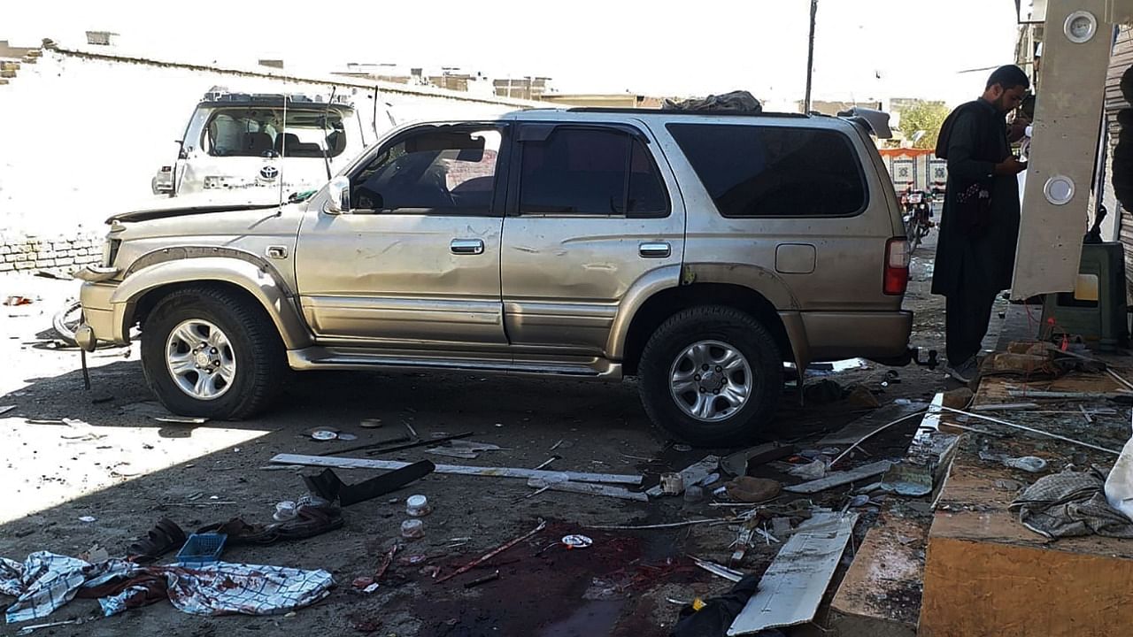 A man stands near a damaged vehicle at the site of bomb blast during a a pro-Palestinian rally, in which six people were killed and another 14 wounded, in Chaman of Pakistan's Balochistan province near the Afghanistan border on May 21, 2021. Credit: AFP Photo