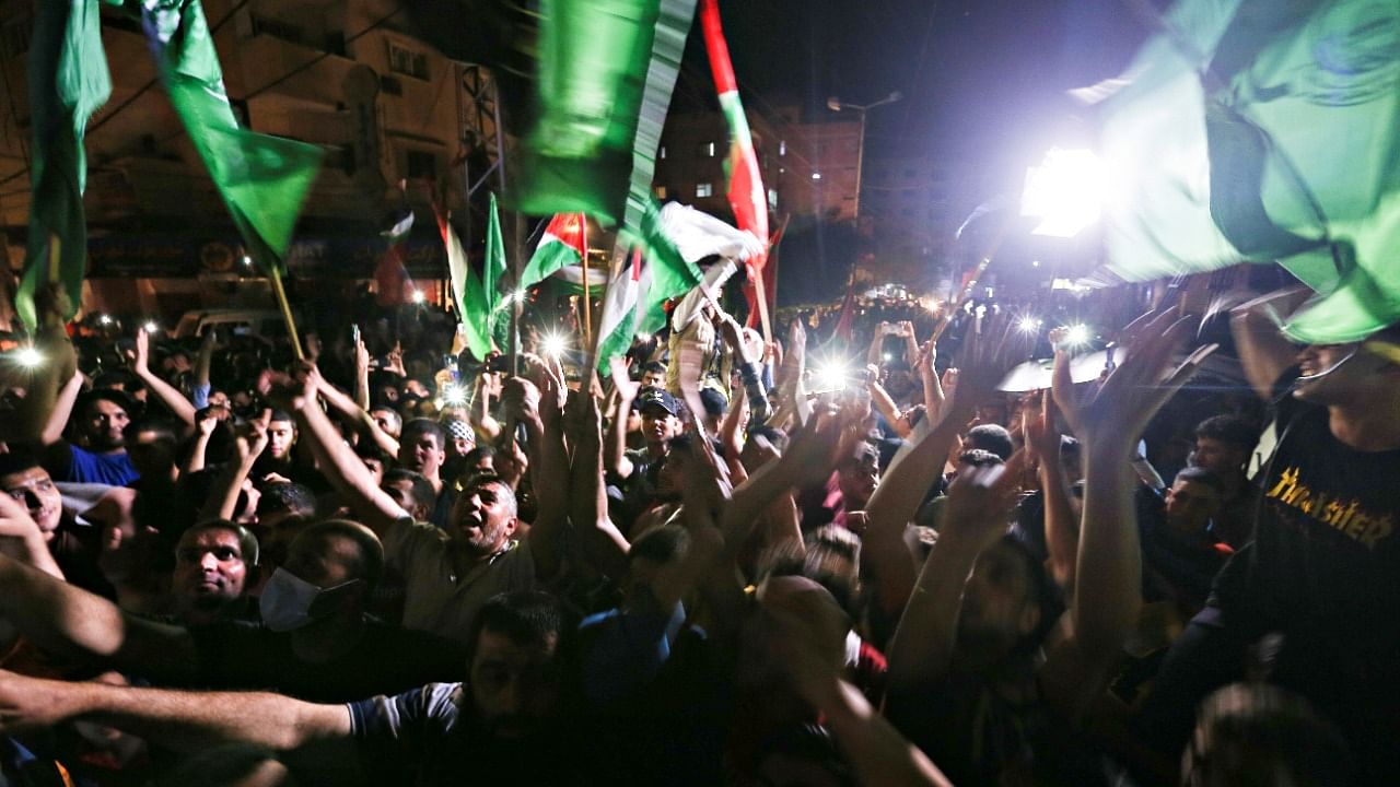 <div class="paragraphs"><p>Palestinians celebrate in the streets following a ceasefire, in the southern Gaza Strip. </p></div>