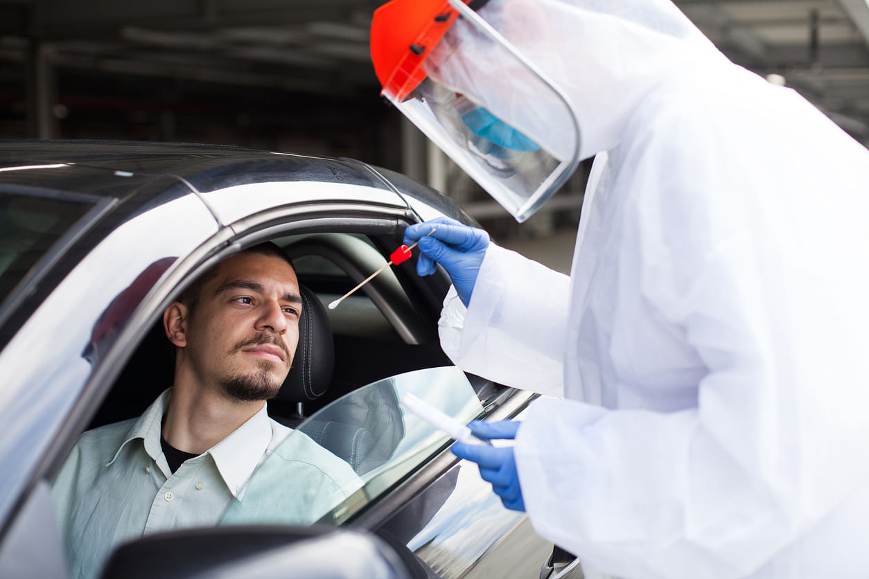 A man undegoes an RT-PCR test at a drive-through testing centre. Credit: iStock Photo