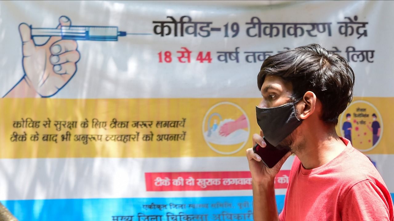 A young person speaks on the phone after receiving his first dose of Covid-19 vaccine, at a school in New Delhi, Wednesday, May 12, 2021. Credit: PTI Photo