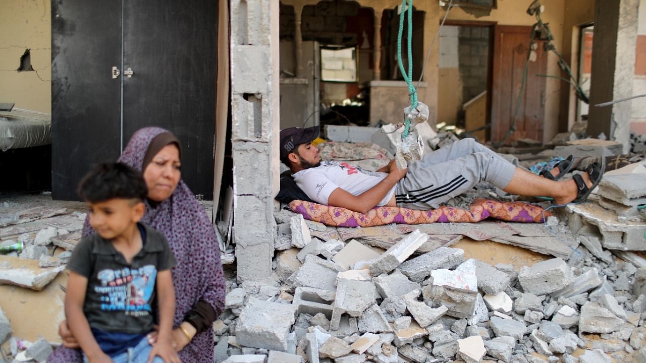 A Palestinian man rests amidst the debris after returning to his damaged house following Israel- Hamas truce, in Beit Hanoun in the northern Gaza Strip. Credit: Reuters Photo