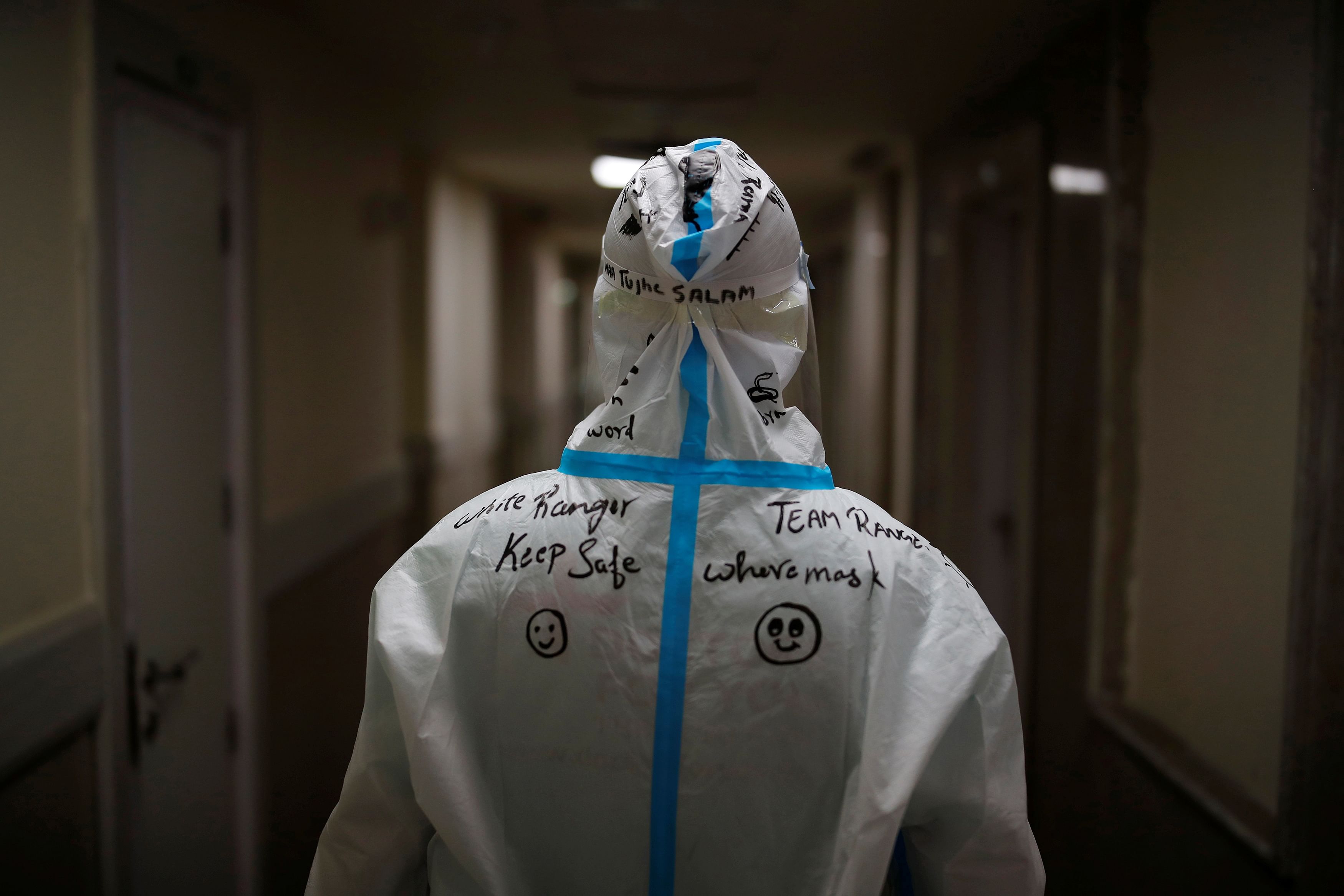 A message is written on the back of a medical staff member by a colleague at an Intensive Care Unit (ICU) ward in Greater Noida. Credit: Reuters Photo