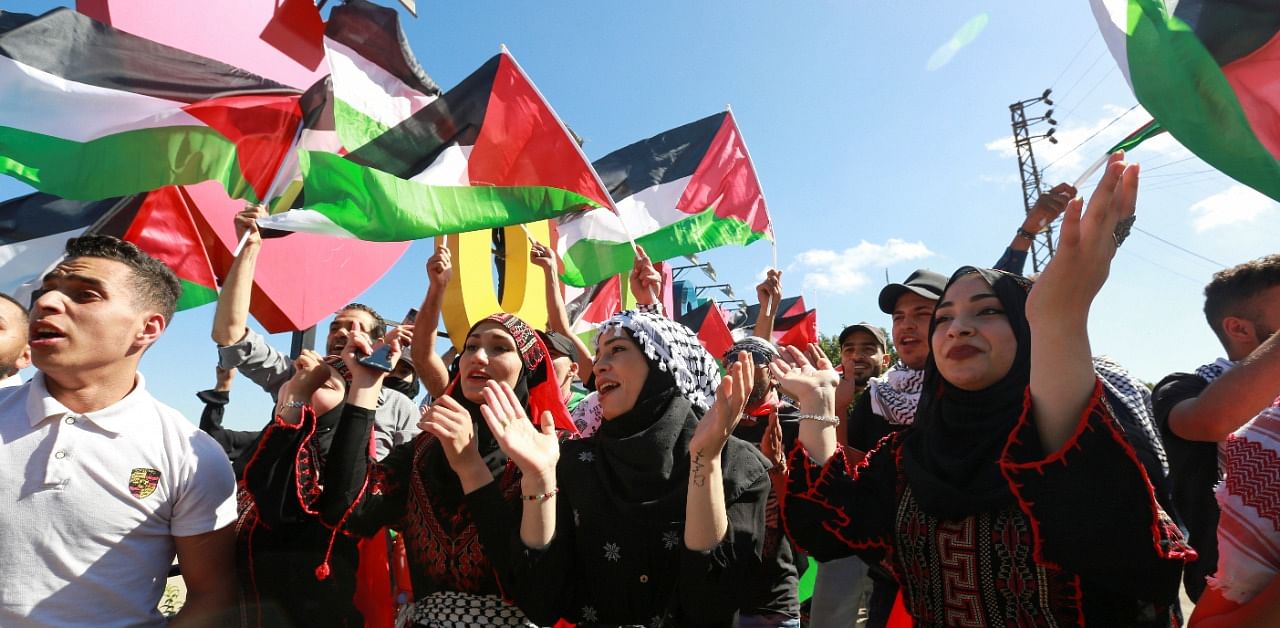 Palestinians living in Lebanon gesture as they celebrate in Adaisseh village. Credit: Reuters Photo