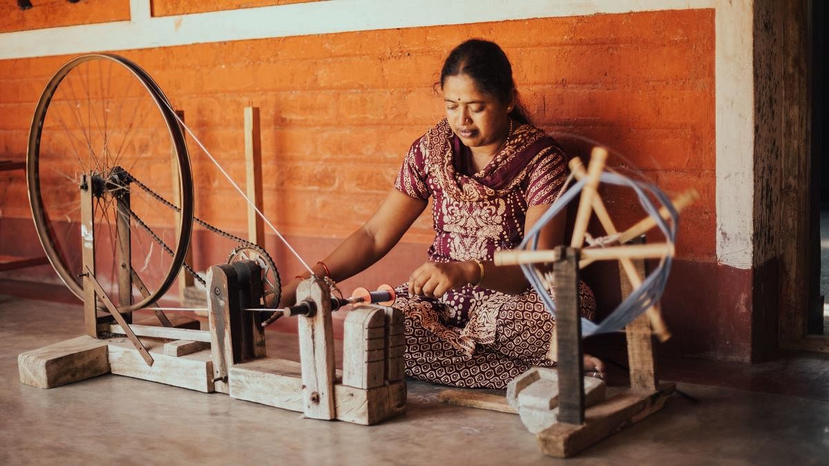 A woman works on the bobbin winding machine at the Janapada Khadi centre in Melukote, Mandya.