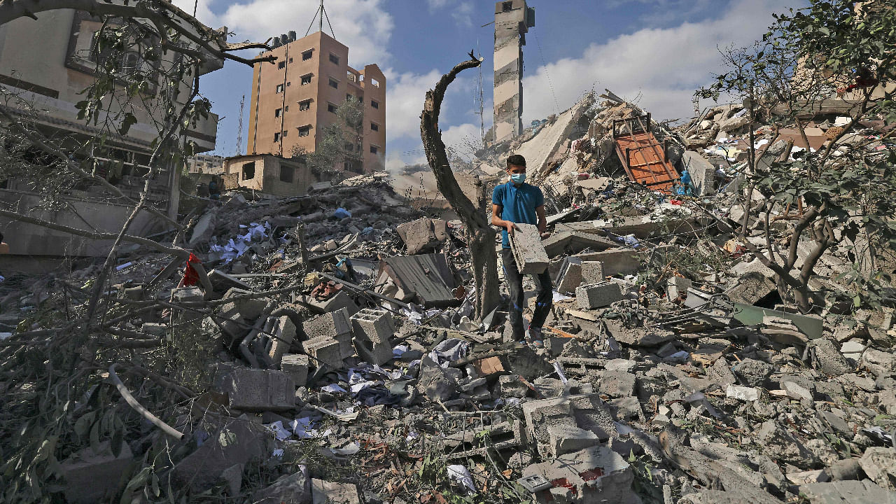  A Palestinian youth looks for salvageable items amid the rubbe of the Kuhail building which was destroyed in an early morning Israeli airstrike on Gaza City. Credit: AFP Photo