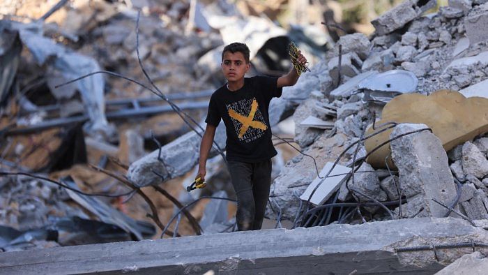 A Palestinian boy inspects the rubble of buildings, destroyed by Israeli strikes, in Beit Lahia in the northern Gaza Strip. Credit: AFP Photo