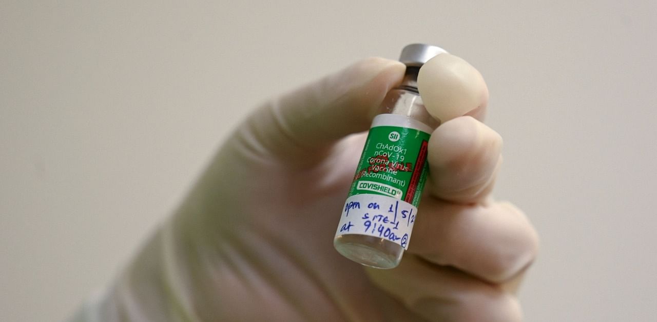  A medical worker holds a vial of Covishield. Credit: AFP Photo