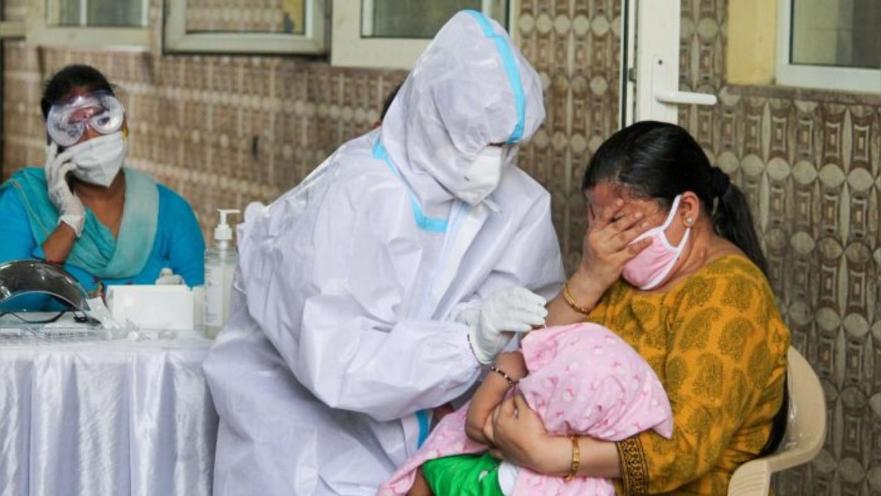 Gurugram: A mother reacts as a medic attempts to collect samples from her infant child for COVID-19 rapid antigen testing, in Gurugram, Tuesday, June 30, 2020. Credit: PTI Photo