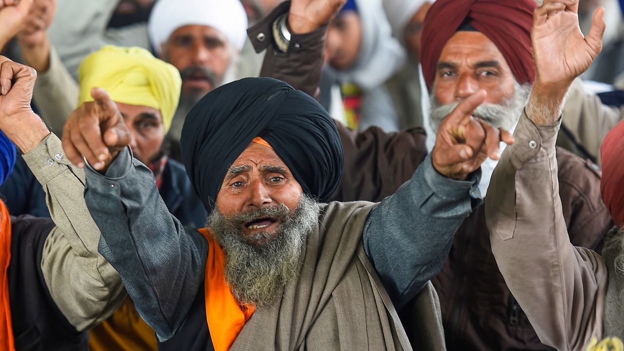 Farmers raise slogans during their ongoing agitation against Centre's farm reform laws, at Singhu border in New Delhi. Credit: PTI File Photo