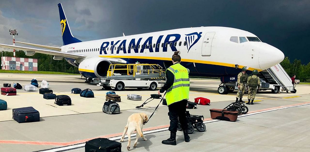 A Belarusian dog handler checks luggages off a Ryanair Boeing 737-8AS. Credit: AFP Photo