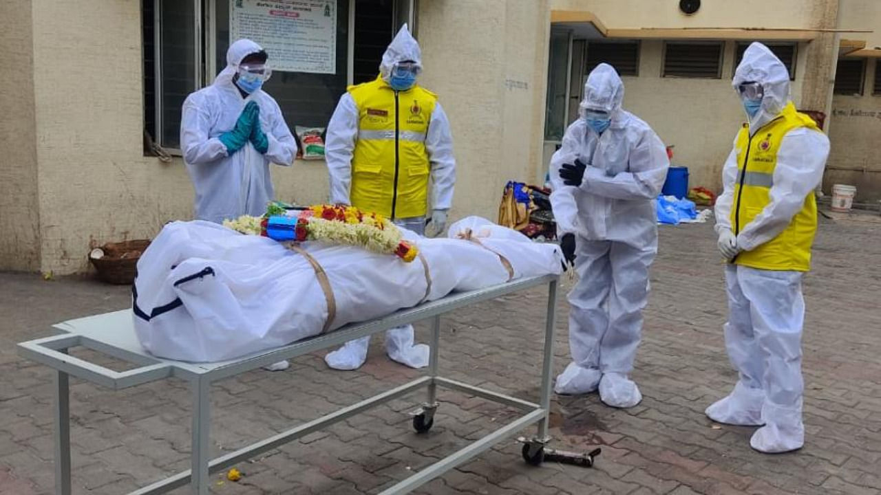 Civil defence members ready a body for cremation. Credit: Civil Defence