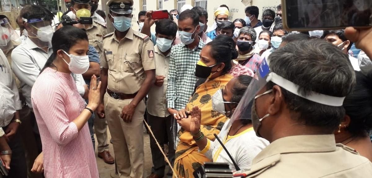 Women share their grievances with Deputy Commissioner Rohini Sindhuri on the premises of K R Hospital in Mysuru on Monday. Credit: DH Photo