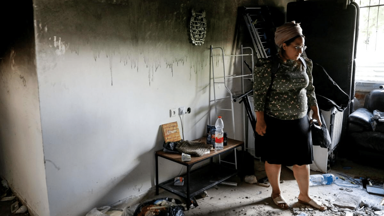 An Israeli woman stands in the midst of scattered objects in her home that was damaged by fire during the intra-communal violence between Palestinians and Israelis in the Israeli Arab city of Lod near Tel Aviv. Credit: AFP Photo